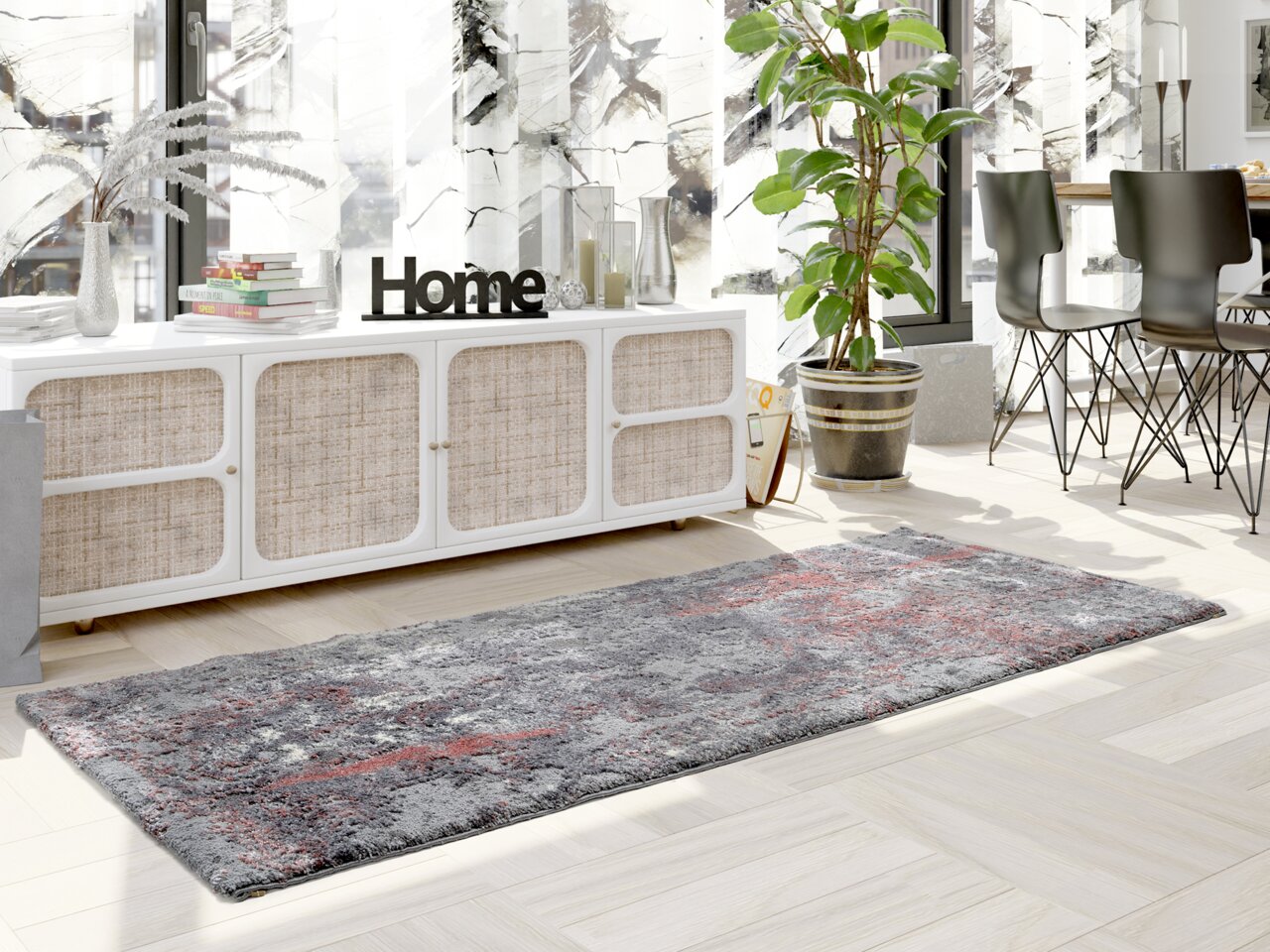 Moderner Designer Teppich in Grau- und Rottönen, in einem hellen Wohnzimmer mit Blick auf ein Sideboard und Pflanzen.