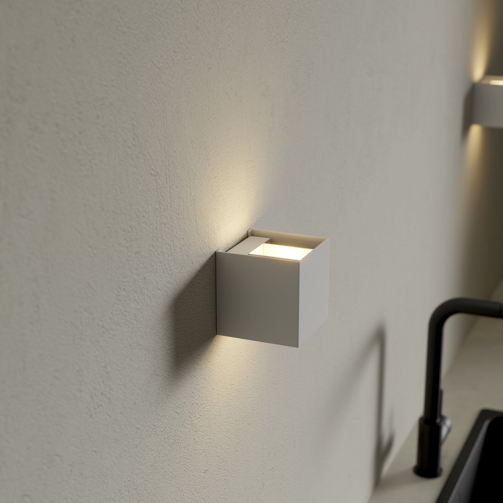 Weiße, kubische LED-Wandleuchte mit Up-&-Downlight an strukturierter Innenwand, seitliche Nahaufnahme aus leicht schräger Perspektive