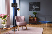 Moderne Stehleuchte mit schwarzem, gemustertem Lampenschirm in einem stilvoll eingerichteten Wohnzimmer, seitliche Perspektive.