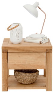 Houten nachtkastje met lade, versierd met een witte lamp, een stapel boeken en een vaas, gezien vanuit het vooraanzicht.