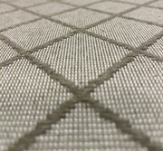 Nahaufnahme einer Mittellehnerauflage mit grauem Rautenmuster aus texturiertem Stoff, perspektivisch von der Seite aufgenommen.