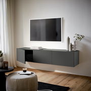 Modernes, dunkelgraues TV-Hängelowboard in einem stilvollen Wohnzimmer, seitliche Perspektive.
