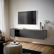 Modernes, dunkelgraues TV-Hängelowboard in einem stilvollen Wohnzimmer, seitliche Perspektive.