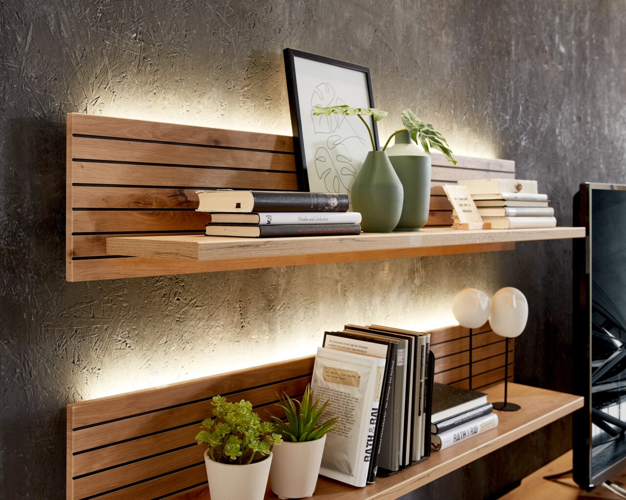 Wandboard aus Holz mit integrierter Beleuchtung, dekoriert mit Büchern, Pflanzen und Vasen, seitliche Perspektive