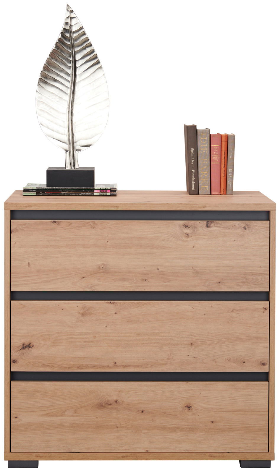 Kommode aus Holz mit drei Schubladen, dekoriert mit einer silbernen Blattskulptur und Büchern, frontal betrachtet.