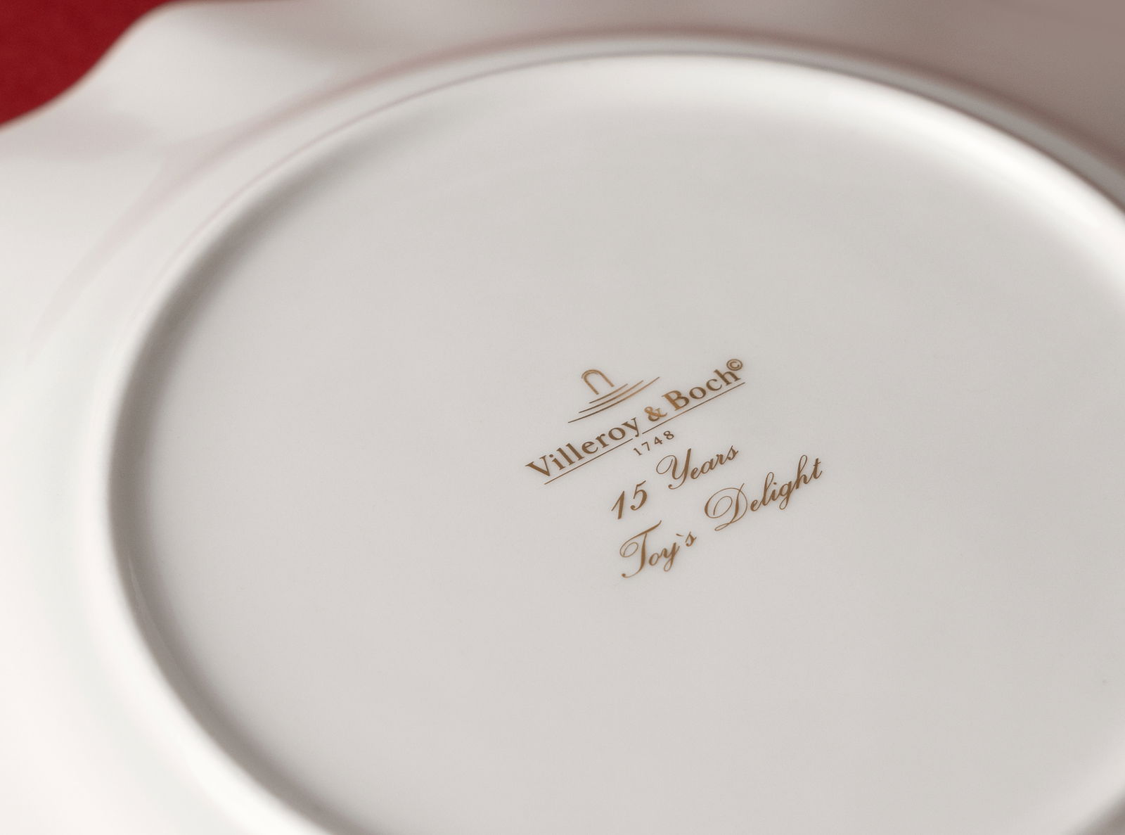 Rückansicht eines Jubiläumstellers von Villeroy & Boch mit goldener Aufschrift '15 Years Toy's Delight'.