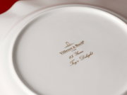 Achterkant van een jubileumbord van Villeroy & Boch met het gouden opschrift '15 Years Toy's Delight'.
