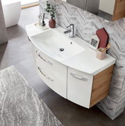 Moderne Badkombination mit weißem Waschbecken und Holzschränken, von oben fotografiert.