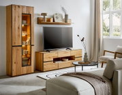 Moderne woonkamer met eikenhouten tv-meubel en hoge vitrinekast met glazen deur en warme LED-verlichting, met tv en wandplank erboven; perspectief: frontaal met lichte hoek van links