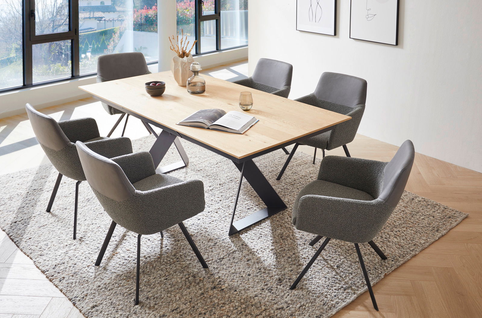 Esszimmer mit modernem Holztisch und sechs grauen Sesseln auf einem Teppich, seitliche Perspektive