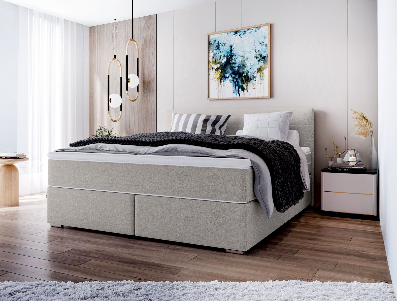 Modernes graues Boxspringbett mit gepolstertem Kopfteil und Bettwäsche in Grau/Schwarz im hellen Schlafzimmer, perspektivisch schräg von vorne links aufgenommen