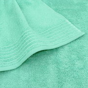 Mintgrünes Frottee-Handtuch mit Bordüre und weicher Struktur, Detailaufnahme aus schräger Draufsicht