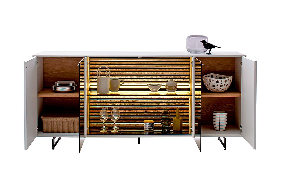 Frontale Ansicht eines modernen Sideboards mit offenen Türen, das dekorative Gegenstände und Geschirr auf Holzregalen zeigt, beleuchtet durch integrierte LED-Leuchten.