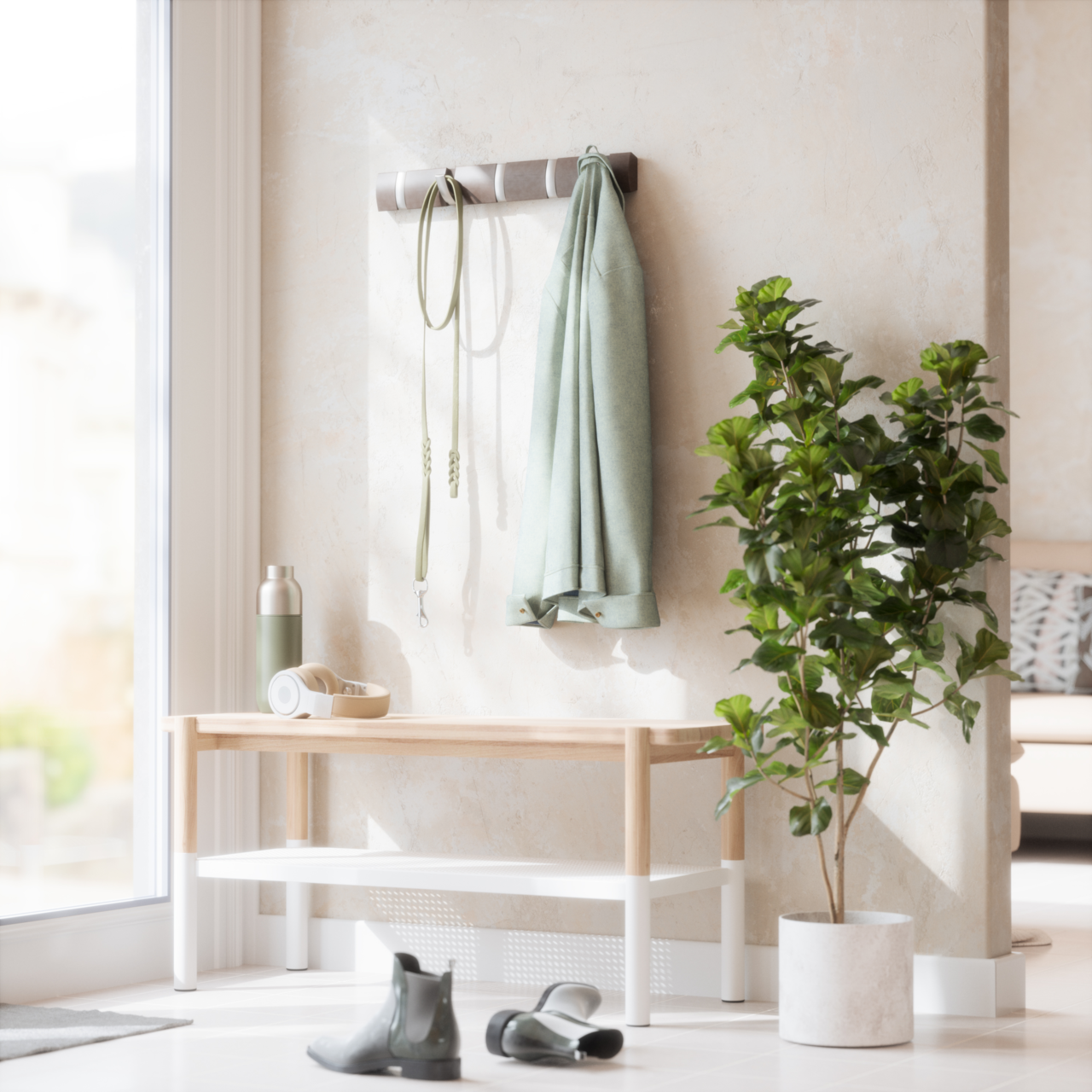 Wandgarderobe mit Haken, an der ein grüner Mantel und eine Leine hängen, daneben eine Bank mit Kopfhörern und einer Trinkflasche, im Vordergrund ein Paar Stiefel und eine grüne Pflanze im Topf, seitliche Perspektive.