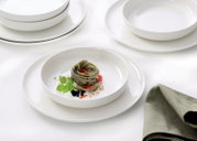 Elegantes Gourmet-Set mit weißen Tellern und Schalen, präsentiert mit einer stilvollen Pasta-Garnitur, aus der Vogelperspektive fotografiert.