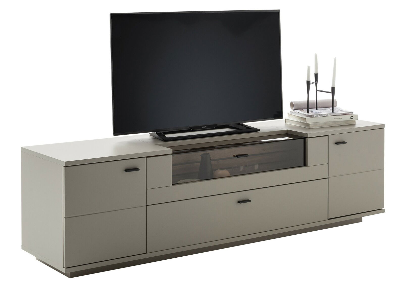 Modernes TV-Element in Beige mit Stauraum, dekoriert mit einem Fernseher, Büchern und Kerzenständer, seitliche Perspektive.