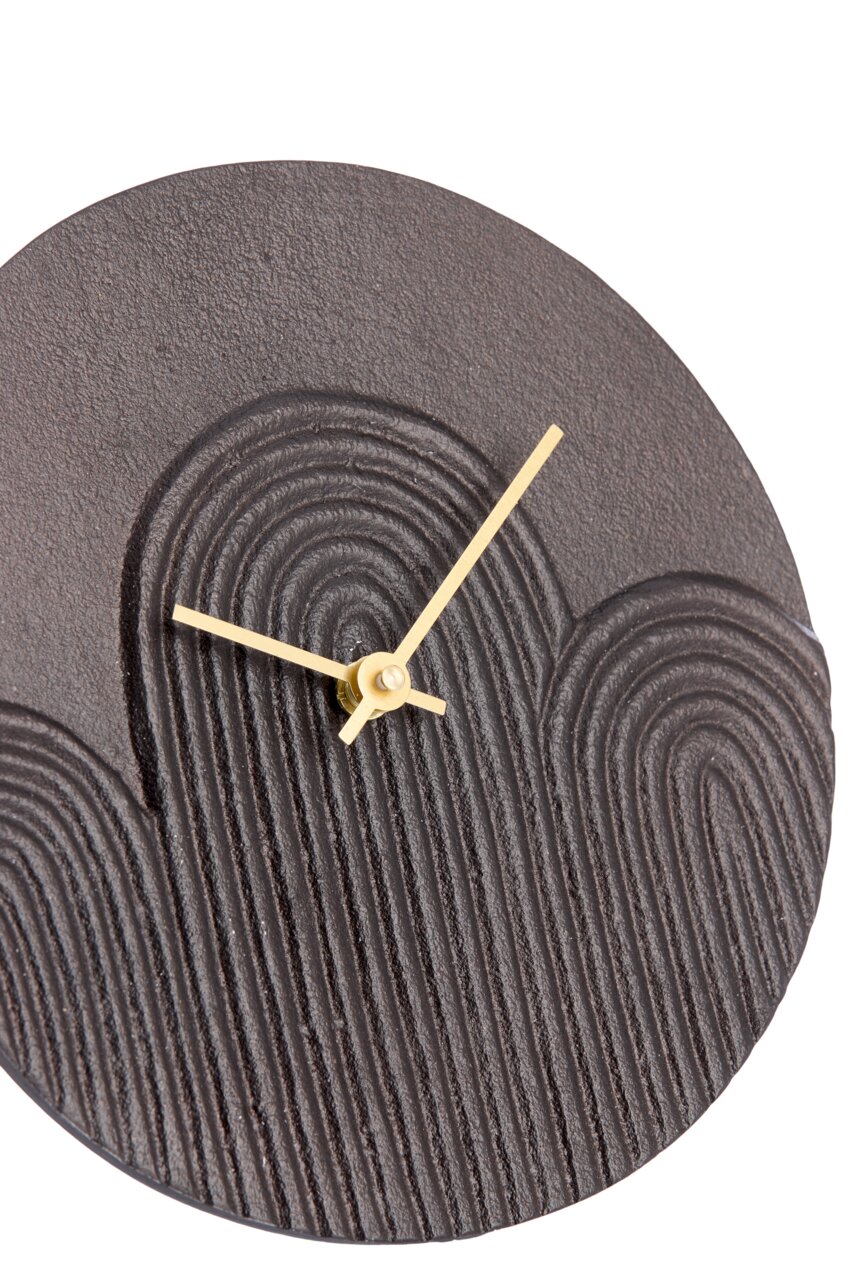 Close-up van een moderne, ronde wandklok met een gestructureerde, donkere wijzerplaat en gouden wijzers, gezien van bovenaf.