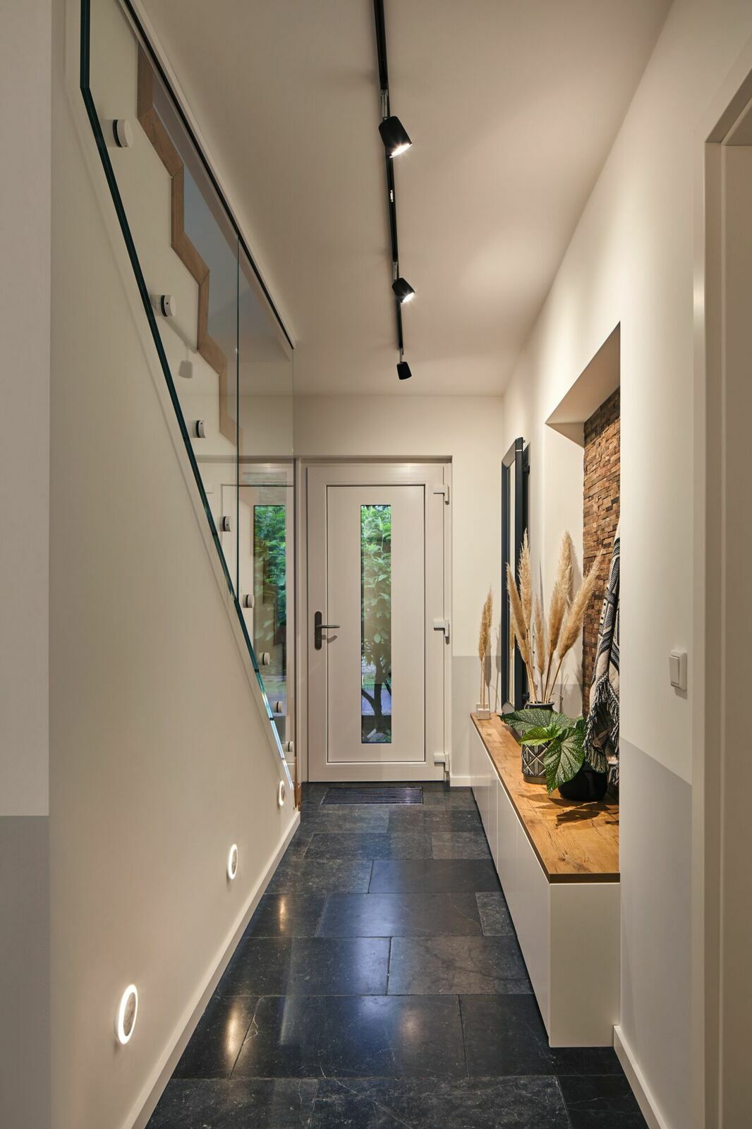 Flur mit moderner Schienenspot-Beleuchtung an der Decke, Blick von der Seite.