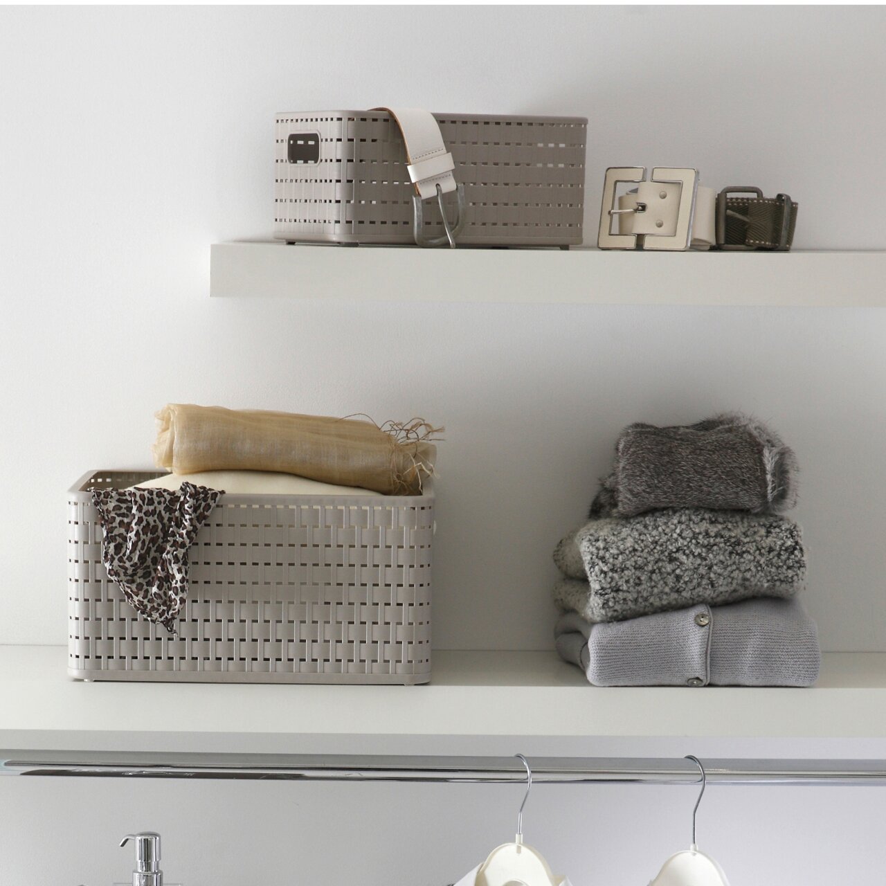 rotho Korb COUNTRY Ein rechteckiger, beige-farbener Korb mit einem Fassungsvermögen von 2 Litern, platziert auf einem Regal. Der Korb hat ein geflochtenes Design und ist von vorne sichtbar. Neben dem Korb liegen gefaltete Kleidungsstücke.