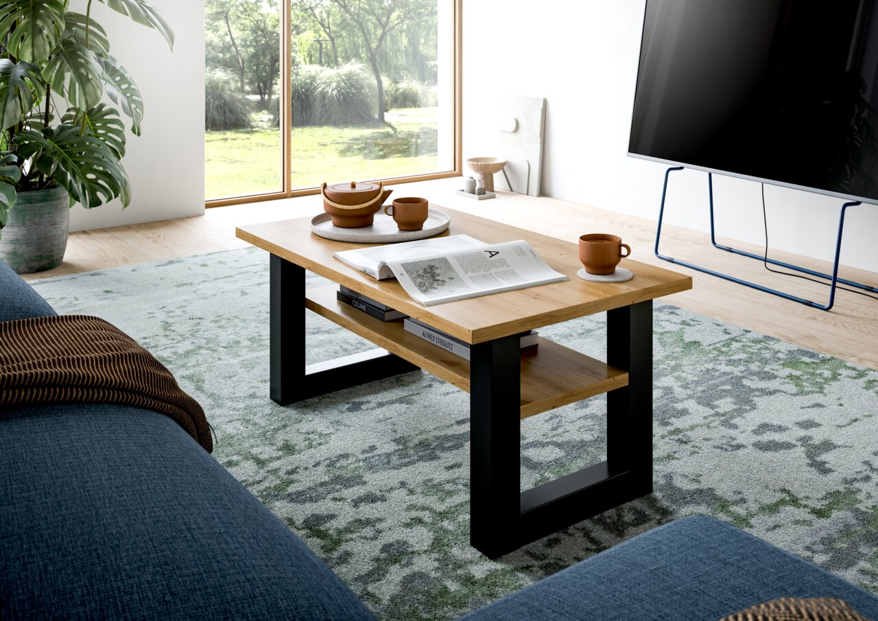 Moderner Couchtisch aus Holz mit schwarzem Metallgestell, seitliche Perspektive, dekoriert mit Teekanne und Tassen in einem hellen Wohnzimmer.