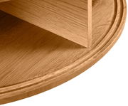 Nahaufnahme eines runden Couchtisches aus Holz mit sichtbarer Maserung, seitliche Perspektive