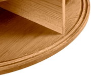 Nahaufnahme eines runden Couchtisches aus Holz mit sichtbarer Maserung, seitliche Perspektive