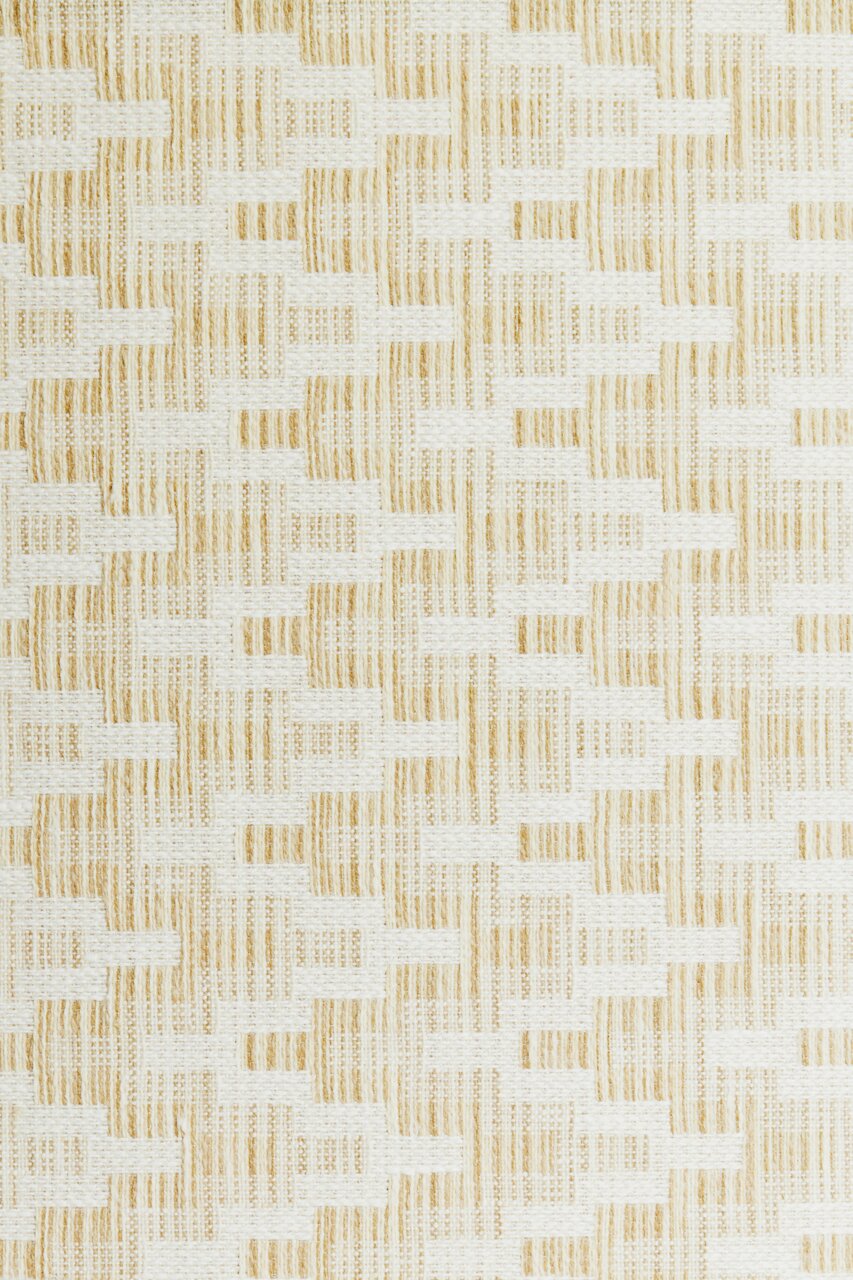 Nahaufnahme eines gewebten Lampenschirms mit einem geometrischen Muster in Beige und Weiß.