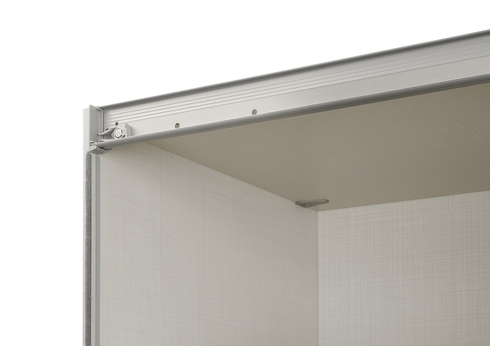 Detailansicht des oberen Innenbereichs eines Schwebetürenschranks mit Metallführungsschiene und heller Holzoptik.