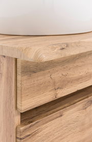 Nahaufnahme eines Waschtisch-Sets aus Holz mit sichtbarer Maserung und abgerundeten Kanten, von der Seite betrachtet.