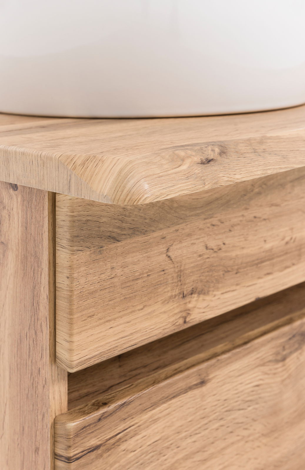 Nahaufnahme eines Waschtisch-Sets aus Holz mit sichtbarer Maserung und abgerundeten Kanten, von der Seite betrachtet.