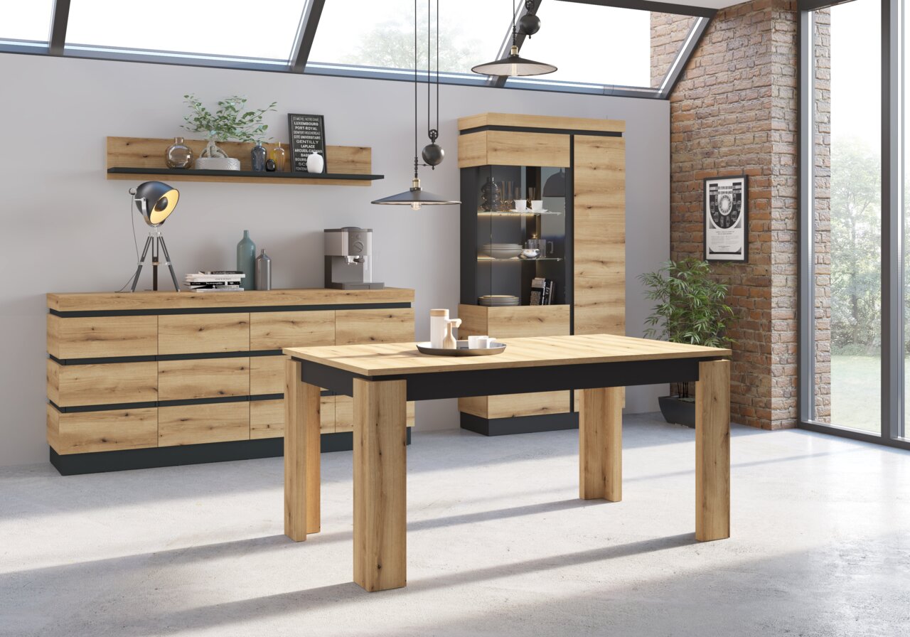 Moderne eethoek met een houten eettafel en zwarte accenten, een dressoir en een vitrinekast op de achtergrond, gezien vanuit de zijkant.