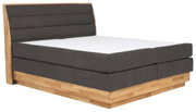 Boxspringbett mit grauem Polster und Holzrahmen, seitliche Perspektive