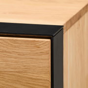 Nahaufnahme einer Ecke eines Highboards aus Holz mit schwarzem Metallrahmen, Perspektive von oben.