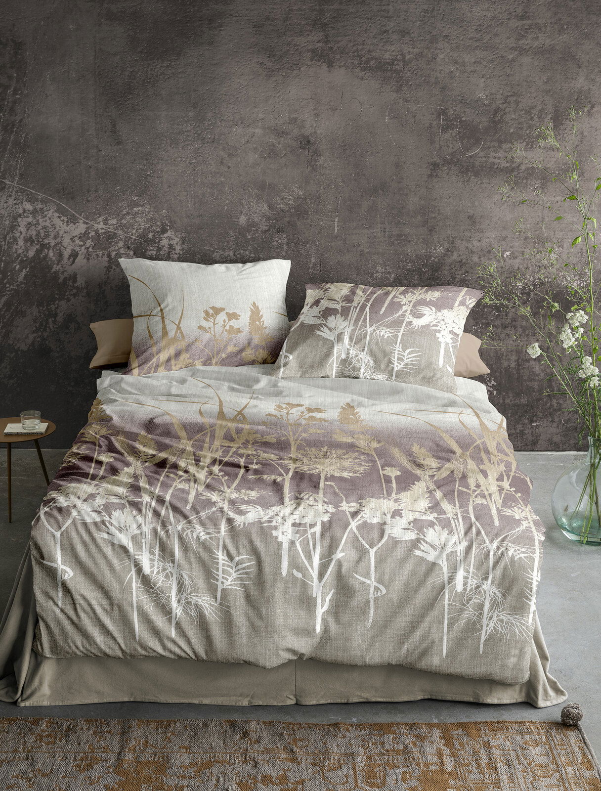 Bettwäsche-Set 155x220cm mit floralem Muster in Naturtönen, frontal fotografiert auf einem Bett mit grauer Wand im Hintergrund.