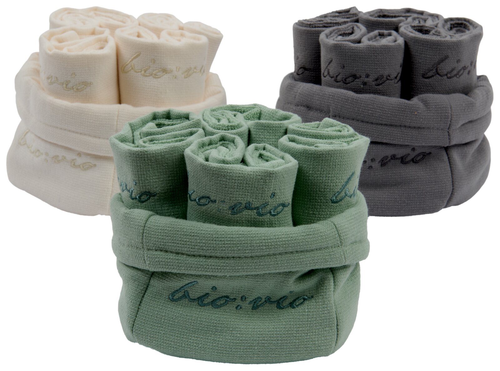 Bio-Vio Gästetuchset Drei Sets von Gästetüchern in den Farben Creme, Grün und Grau, aufgerollt und in Körben präsentiert, mit der Aufschrift 'bio:vio'. Perspektive von vorne.