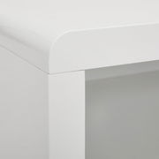 Nahaufnahme einer Ecke eines weißen TV-Lowboards mit abgerundeten Kanten, Perspektive von oben.