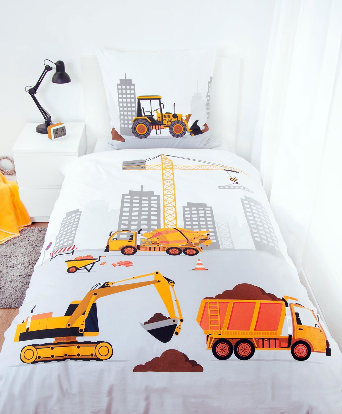Renforcé-Bettwäsche mit Baustellenmotiv, zeigt Bagger, Kran und Lastwagen in einer städtischen Umgebung. Perspektive von oben auf das Bett.
