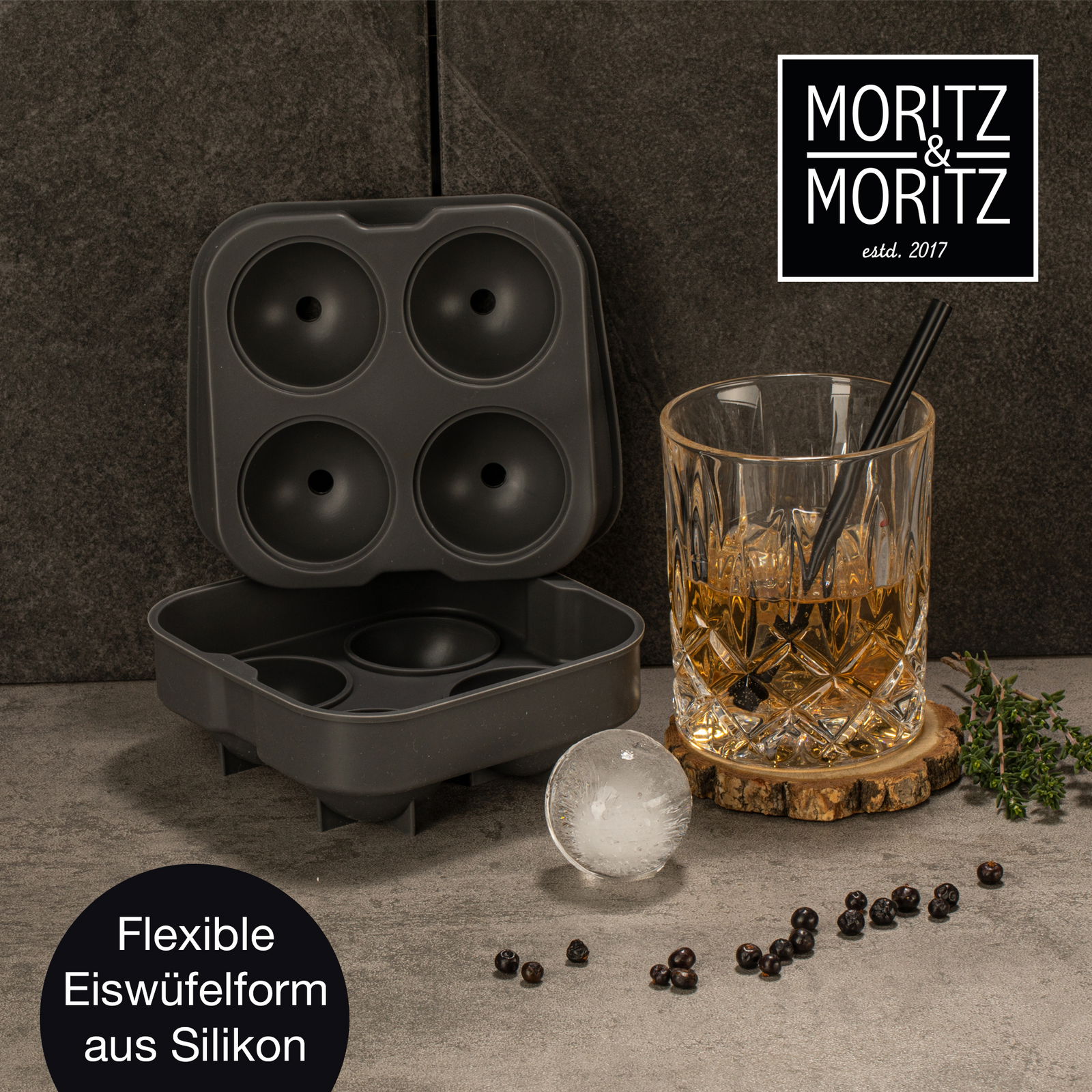 Runde Silikon-Eiswürfelform in geöffneter Perspektive neben einem Glas mit Getränk und einer runden Eiskugel.