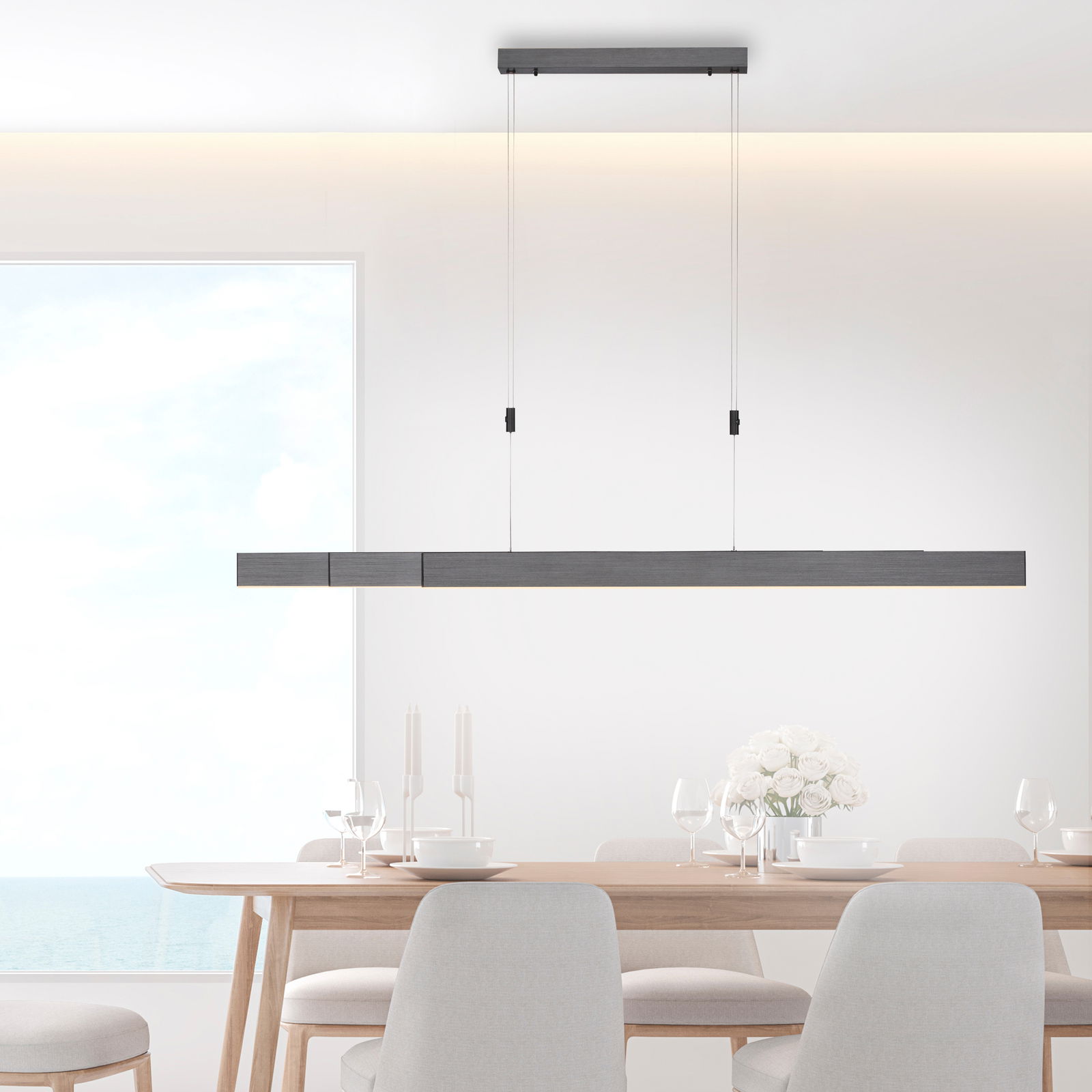 Moderne LED-Pendelleuchte PURE MOTO in minimalistischem Design, hängend über einem Esstisch, seitliche Perspektive.