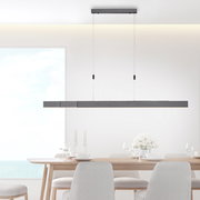 Moderne LED-Pendelleuchte PURE MOTO in minimalistischem Design, hängend über einem Esstisch, seitliche Perspektive.