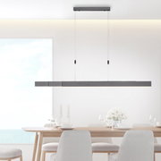 Moderne LED-Pendelleuchte PURE MOTO in minimalistischem Design, hängend über einem Esstisch, seitliche Perspektive.