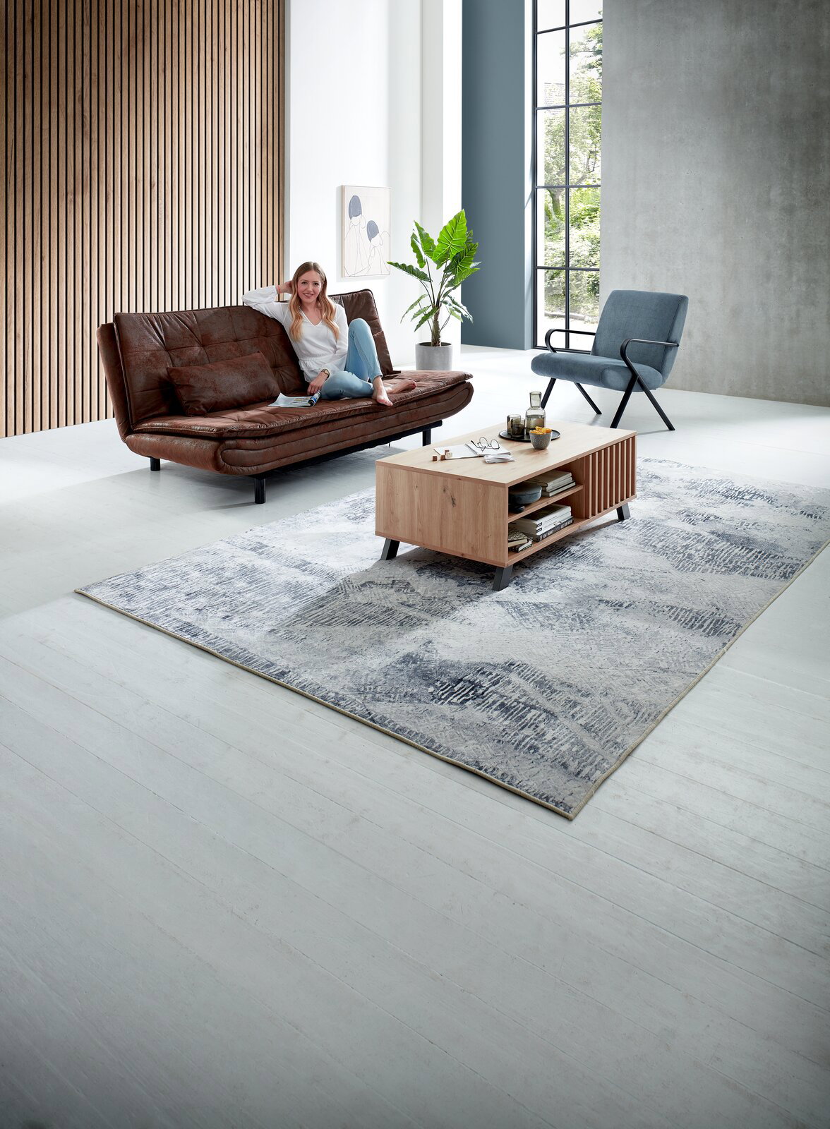 Z2 Couchtisch MEDAN Moderner Couchtisch aus Holz mit Regalfächern, frontal im Wohnzimmer platziert, umgeben von einem Sofa, einem Sessel und einem Teppich.