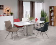 Moderner Esstisch mit weißer Tischplatte und sechs bunten Stühlen in einem stilvoll eingerichteten Esszimmer, seitliche Perspektive.