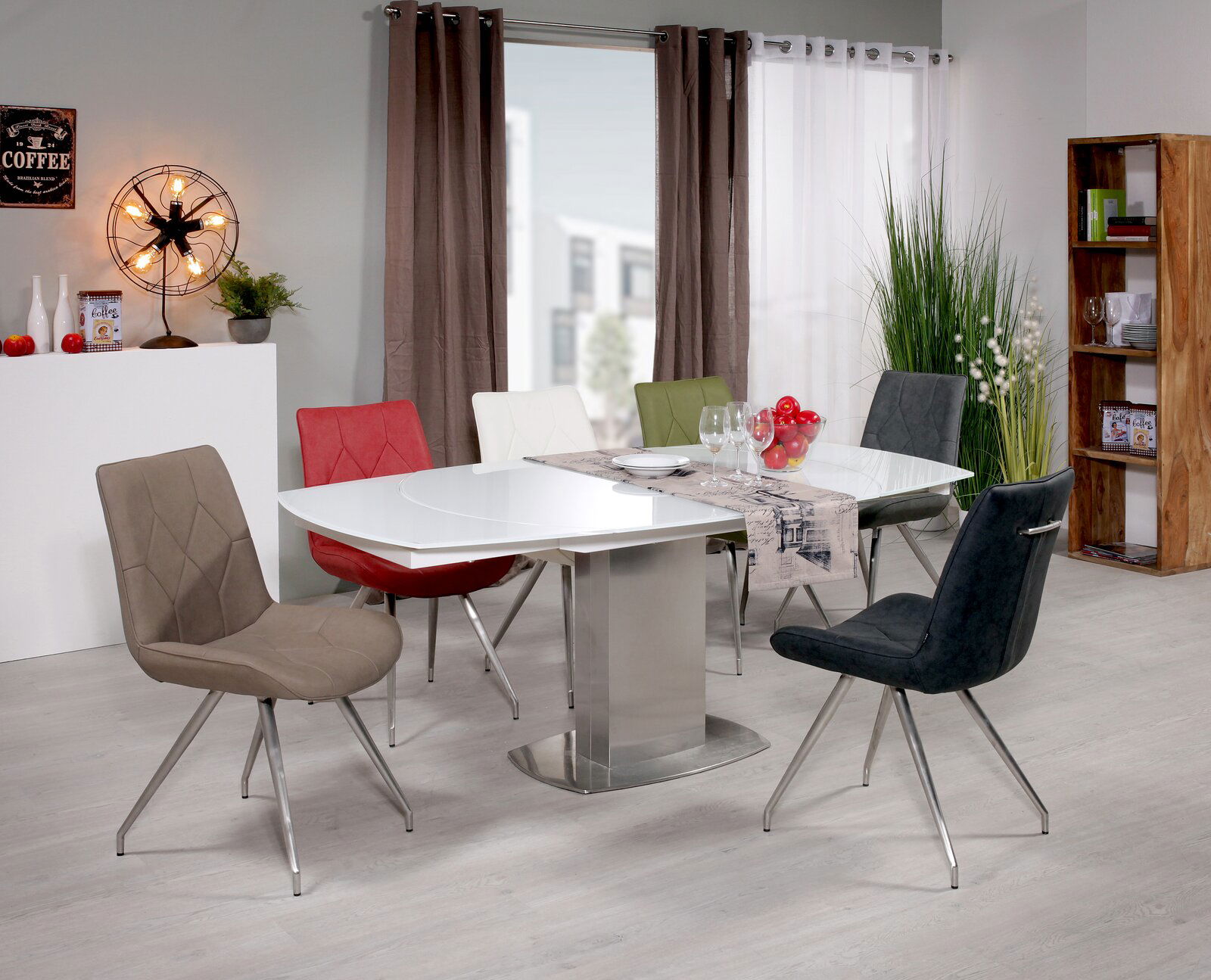 Moderner Esstisch mit weißer Tischplatte und sechs bunten Stühlen in einem stilvoll eingerichteten Esszimmer, seitliche Perspektive.