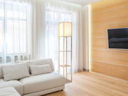 Moderne Stehleuchte TABITHA von Globo Lighting in einem hellen Wohnzimmer, seitliche Perspektive.