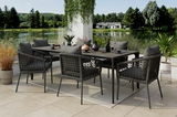 Moderner Gartensessel mit dunklem Geflecht und Kissen, Teil einer stilvollen Outdoor-Essgruppe auf einer Terrasse mit Seeblick, seitliche Perspektive.