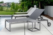 Moderne Rollenliege aus Metall mit verstellbarer Rückenlehne, seitliche Perspektive, auf einer Terrasse neben einem Pool mit grüner Landschaft im Hintergrund.