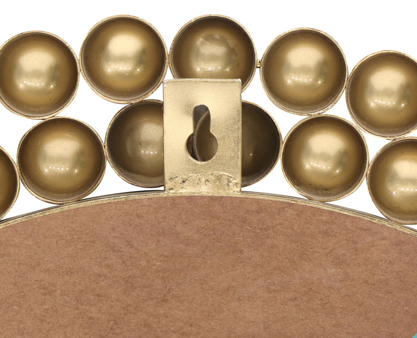 Achterkant van een ronde spiegel met gouden, bolvormige versieringen en een ophanging.