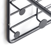 Nahaufnahme einer schwarzen Wandgarderobe aus Metall mit runden Haken, seitliche Perspektive