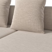 Nahaufnahme eines Lounge-Sets mit beigen Kissen und Textilbezug, Perspektive von vorne.